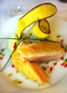 Plate of seared salmon, plantain, garnish, white plate